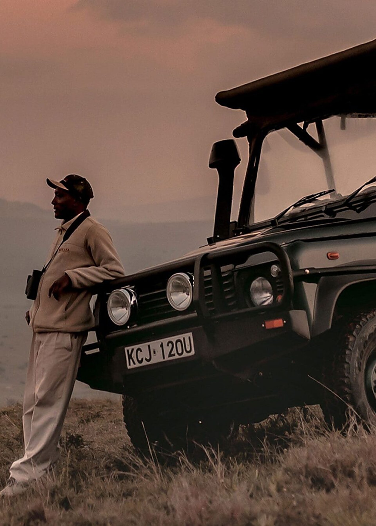 Nissa Ole Kinyaga beside his safari vehicle at dusk on the Borana Conservancy